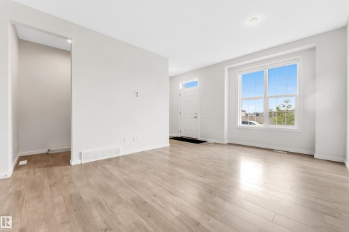 Unfurnished living room with light wood finished floors - 2095 Maple Road, Edmonton, AB - Indoor Photo Showing Other Room