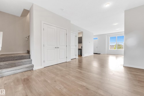 Unfurnished living room with light wood-type flooring and stairway - 2095 Maple Road, Edmonton, AB - Indoor Photo Showing Other Room