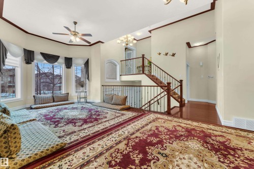 Living area with ornamental molding, a towering ceiling, a chandelier, stairs, and a ceiling fan - 2012 69 Street, Edmonton, AB - Indoor Photo Showing Other Room
