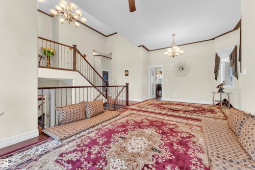 Entrance foyer featuring a chandelier, crown molding, a high ceiling, and a ceiling fan - 2012 69 Street, Edmonton, AB - Indoor