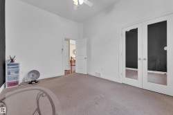 Carpeted bedroom featuring baseboards and a ceiling fan - 