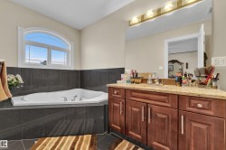 Full bathroom with vanity, a garden tub, and tile patterned floors - 