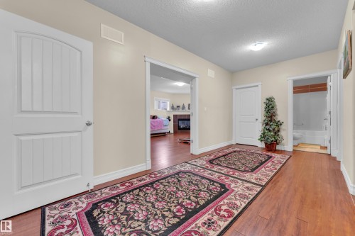 Entryway featuring a textured ceiling, wood finished floors, and a tile fireplace - 2012 69 Street, Edmonton, AB - Indoor Photo Showing Other Room