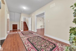 Corridor featuring a textured ceiling, dark wood-type flooring, and stairway - 
