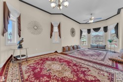 Sitting room with ornamental molding, a chandelier, a ceiling fan, and wood finished floors - 