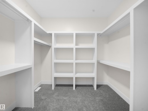 Walk in closet featuring dark colored carpet - 46 Waverly Way, Fort Saskatchewan, AB - Indoor With Storage