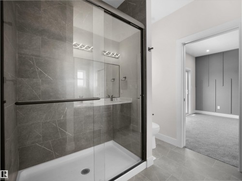 Full bath featuring a stall shower, carpet floors, and tile patterned floors - 46 Waverly Way, Fort Saskatchewan, AB - Indoor Photo Showing Bathroom