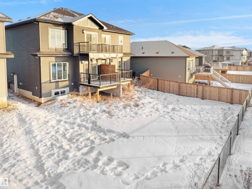 Snow covered back of property with a fenced backyard, a balcony, and a residential view - 46 Waverly Way, Fort Saskatchewan, AB - Outdoor