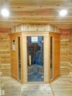 Relaxing sauna / steam room featuring wooden walls, wooden ceiling, and hardwood / wood-style flooring - 