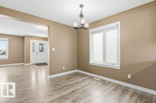 Empty room with light wood-style flooring and a chandelier - 2 Wingate Way, Fort Saskatchewan, AB - Indoor Photo Showing Other Room