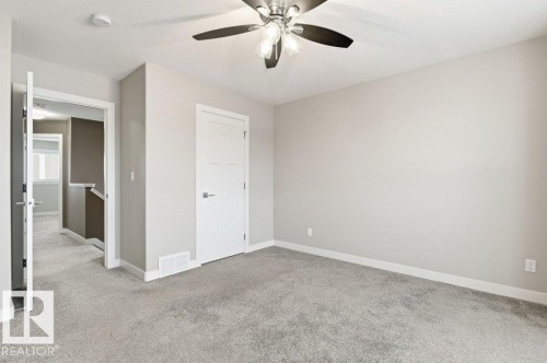 Unfurnished bedroom with light colored carpet, a ceiling fan, and a textured ceiling - 2 Wingate Way, Fort Saskatchewan, AB - Indoor Photo Showing Other Room