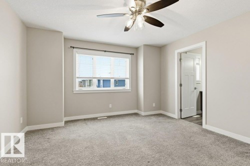 Spare room with light colored carpet, ceiling fan, and a textured ceiling - 2 Wingate Way, Fort Saskatchewan, AB - Indoor Photo Showing Other Room