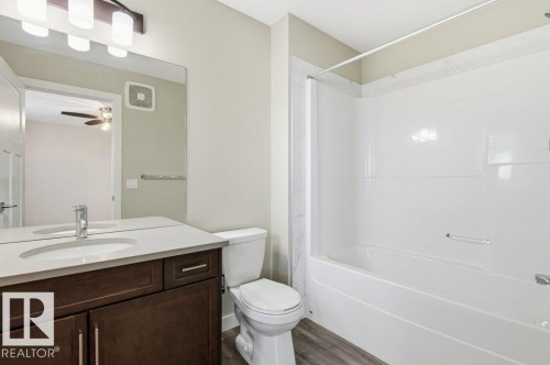 Bathroom with vanity, shower / bath combination, and dark wood-style flooring - 2 Wingate Way, Fort Saskatchewan, AB - Indoor Photo Showing Bathroom