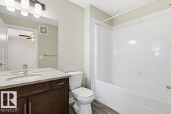Bathroom with vanity, shower / bath combination, and dark wood-style flooring - 
