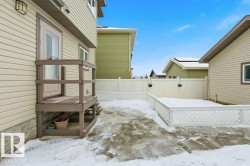 Snow covered patio featuring a fenced backyard and a wooden deck - 