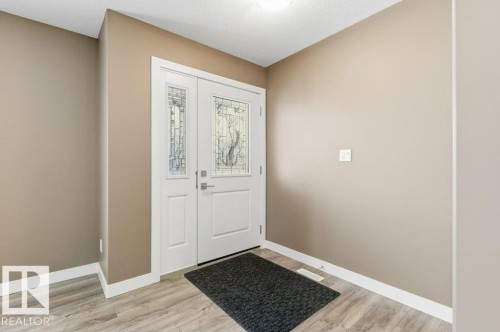 Foyer entrance featuring light wood-type flooring and a textured ceiling - 2 Wingate Way, Fort Saskatchewan, AB - Indoor Photo Showing Other Room