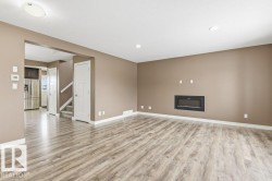 Unfurnished living room featuring stairs, a fireplace, light wood finished floors, and recessed lighting - 