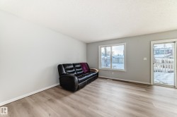 Sitting room featuring light wood-type flooring and a textured ceiling - 