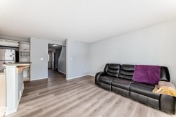 Living room featuring light wood-style floors and a textured ceiling - 