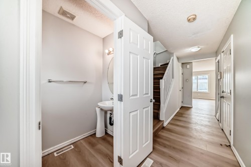 Bathroom featuring light wood-style floors and a textured ceiling - 7731 8 Avenue, Edmonton, AB - Indoor Photo Showing Other Room