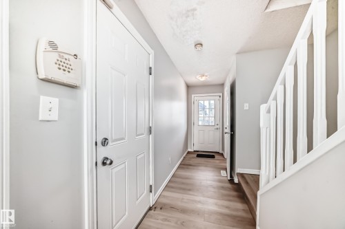 Doorway to outside with wood finished floors and a textured ceiling - 7731 8 Avenue, Edmonton, AB - Indoor Photo Showing Other Room