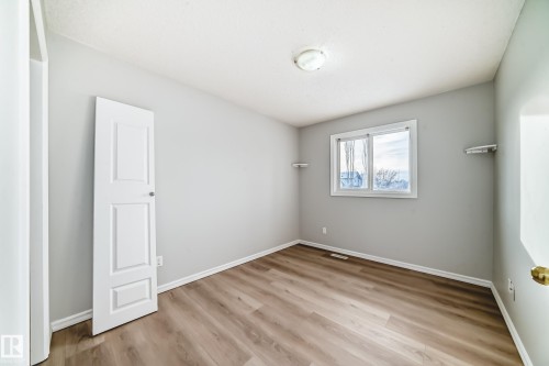 Empty room featuring light wood finished floors and baseboards - 7731 8 Avenue, Edmonton, AB - Indoor Photo Showing Other Room