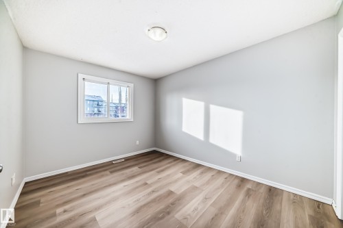 Spare room with light wood-style flooring and baseboards - 7731 8 Avenue, Edmonton, AB - Indoor Photo Showing Other Room