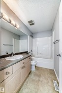 Bathroom featuring vanity, shower / bath combination, and a textured ceiling - 