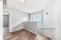 Corridor featuring an upstairs landing and light wood-style floors - 