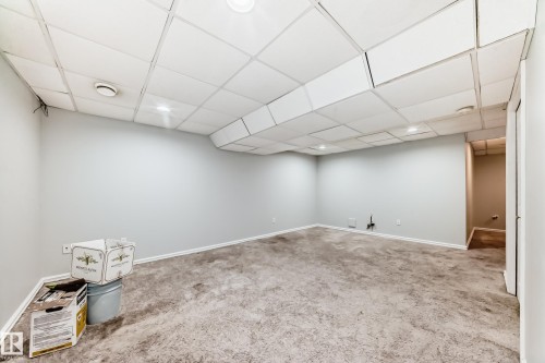 Finished basement featuring a drop ceiling and carpet floors - 7731 8 Avenue, Edmonton, AB - Indoor