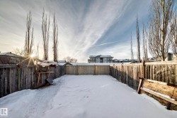 Yard covered in snow featuring a fenced backyard and a residential view - 
