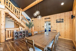 Dining room featuring dark wood-type flooring, stairs, and wood walls - 