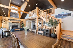 Dining space with stairs, a fireplace, dark wood-type flooring, a chandelier, and recessed lighting - 