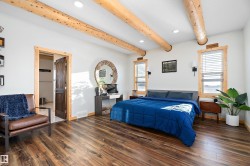 Bedroom featuring beam ceiling, wood finished floors, and recessed lighting - 