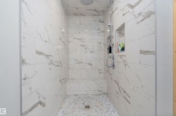 Full bath with a marble finish shower - 