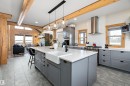 Kitchen featuring gray cabinetry, a center island with sink, wall chimney exhaust hood, appliances with stainless steel finishes, and beamed ceiling - 19003 Twp Rd 522, Rural Beaver County, AB  - Indoor Photo Showing Kitchen With Double Sink With Upgraded Kitchen 