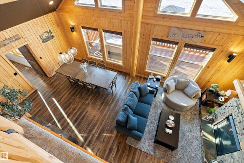Living area with wooden walls, wood finished floors, and high vaulted ceiling - 19003 Twp Rd 522, Rural Beaver County, AB - Indoor Photo Showing Other Room