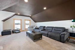 Living room with vaulted ceiling, a textured ceiling, light carpet, and recessed lighting - 