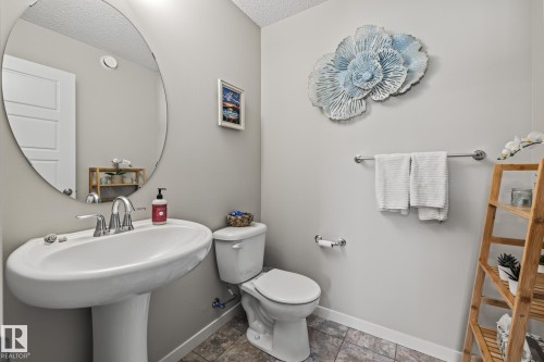Half bathroom with toilet and a textured ceiling - 20110 27 Avenue, Edmonton, AB - Indoor Photo Showing Bathroom