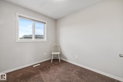 Empty room with dark carpet and a textured ceiling - 