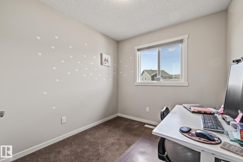 Bedroom featuring a textured ceiling and dark carpet - 20110 27 Avenue, Edmonton, AB - Indoor