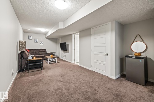 Living room with dark carpet and a textured ceiling - 20110 27 Avenue, Edmonton, AB - Indoor