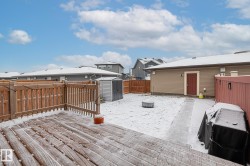 Snow covered deck with a storage shed, a fenced backyard, and an outdoor fire pit - 