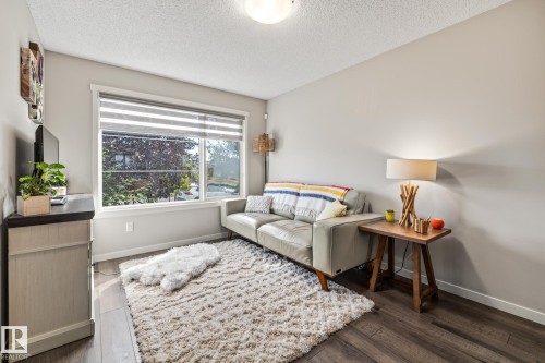 Living room featuring a textured ceiling and wood finished floors - 20110 27 Avenue, Edmonton, AB - Indoor Photo Showing Other Room
