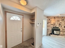 Foyer featuring a wood stove, a textured ceiling, and track lighting - 