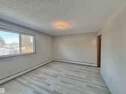 Spare room featuring a baseboard heating unit, light wood-type flooring, and a textured ceiling - 
