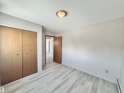 Unfurnished bedroom featuring a baseboard heating unit, light wood finished floors, a closet, and a textured ceiling - 