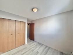 Unfurnished bedroom with a textured ceiling, a closet, and light wood-style flooring - 
