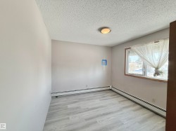 Spare room with a baseboard radiator, a textured ceiling, and light wood-style floors - 