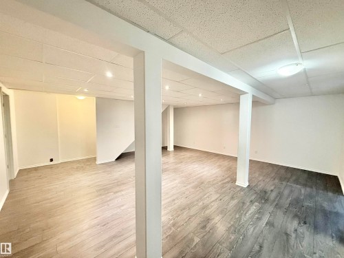 Finished below grade area with a paneled ceiling and light wood-style floors - 2112 104B Street, Edmonton, AB - Indoor